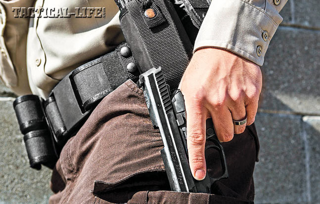 Step 2. With the magazine cleared from the pistol, now move to stow the handgun in an accessible support-side pocket to facilitate a reload.