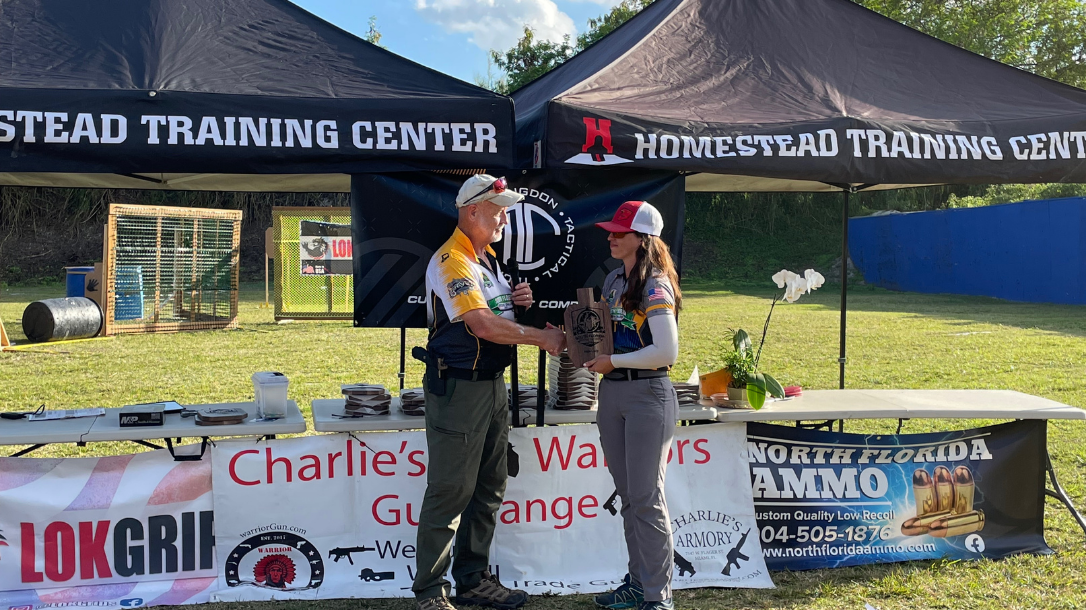 2022 South Florida Defensive Challenge Match Director Joyce Hernandez presents a plaque to Rick Lund