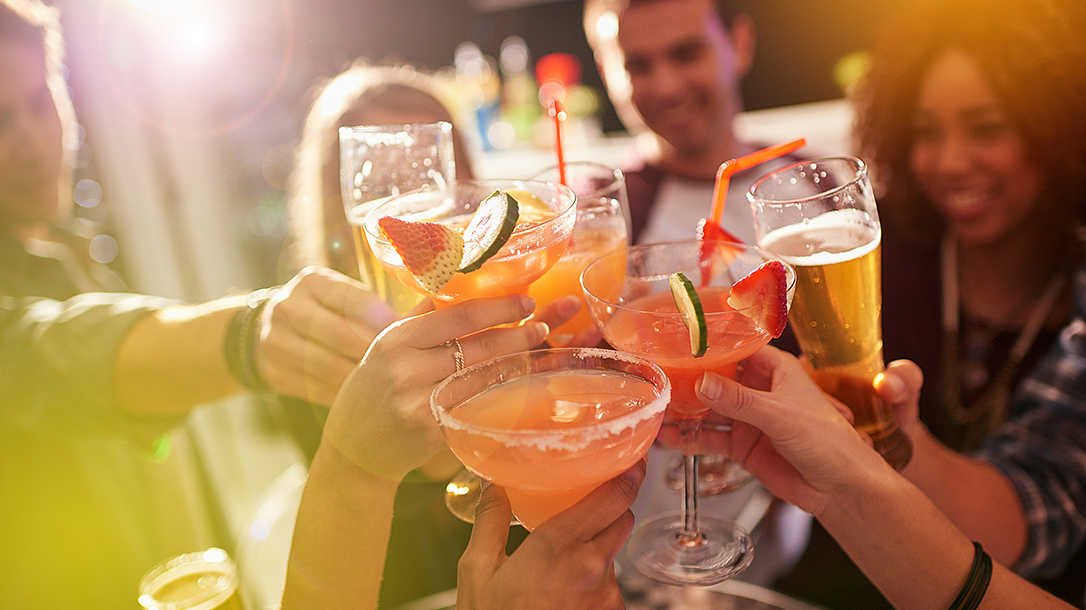Shot of a group of people toasting with their drinks at a nightclub