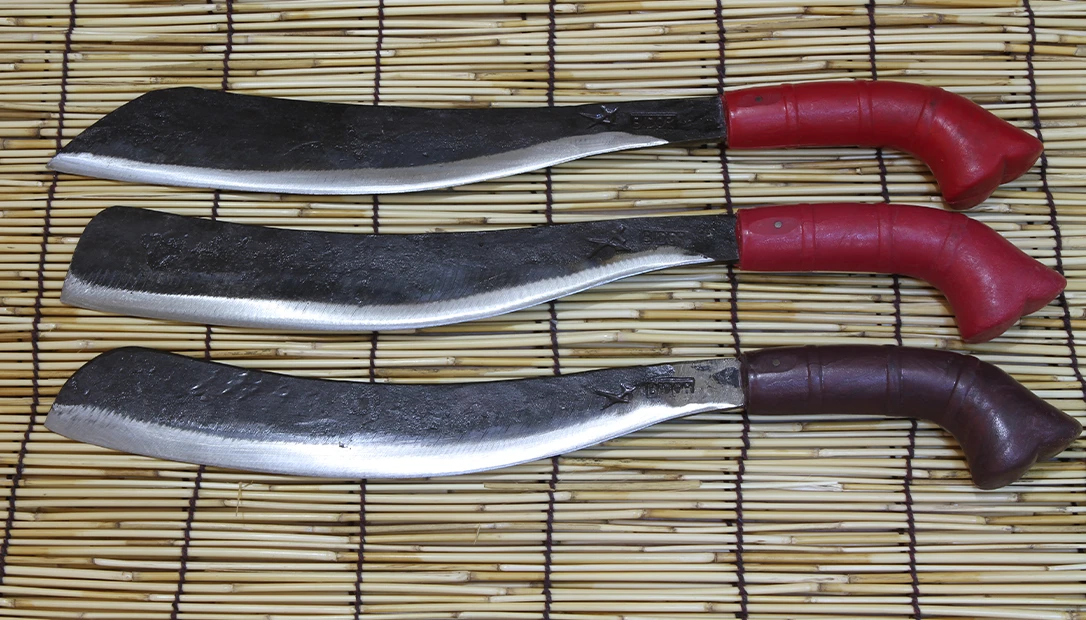 Parangs on display in a Malaysian forge, showcasing the vibrant handles and time-honored designs unique to the region.
