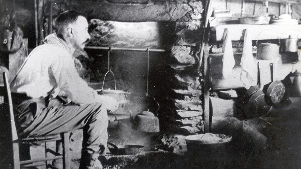Horace Kephart sits in his cabin and enjoys a fire.