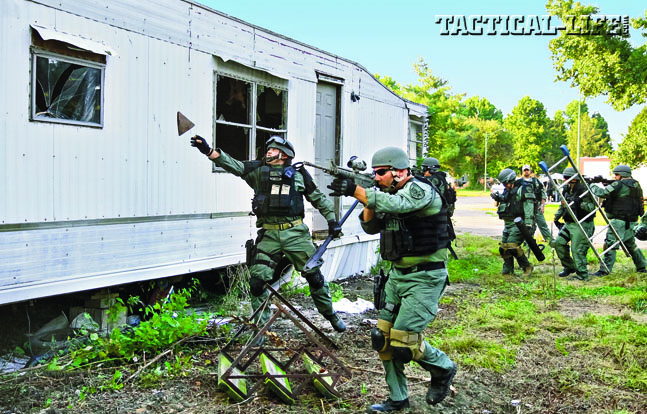 Special Response Team deputies move in to break and rake the windows of a trailer during a simulated entry.