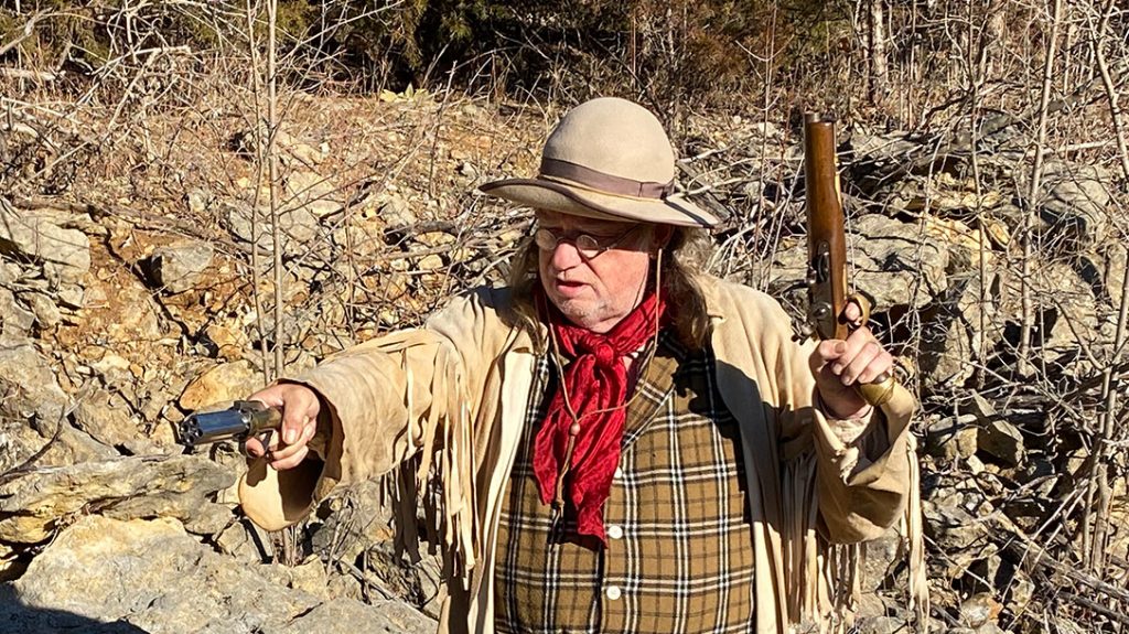 The author wielding both the pepperbox pistol and a single-shot pistol.