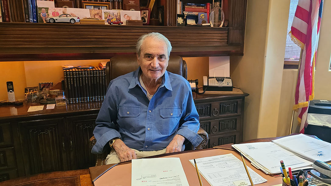 John Bianchi sits at his desk at home.