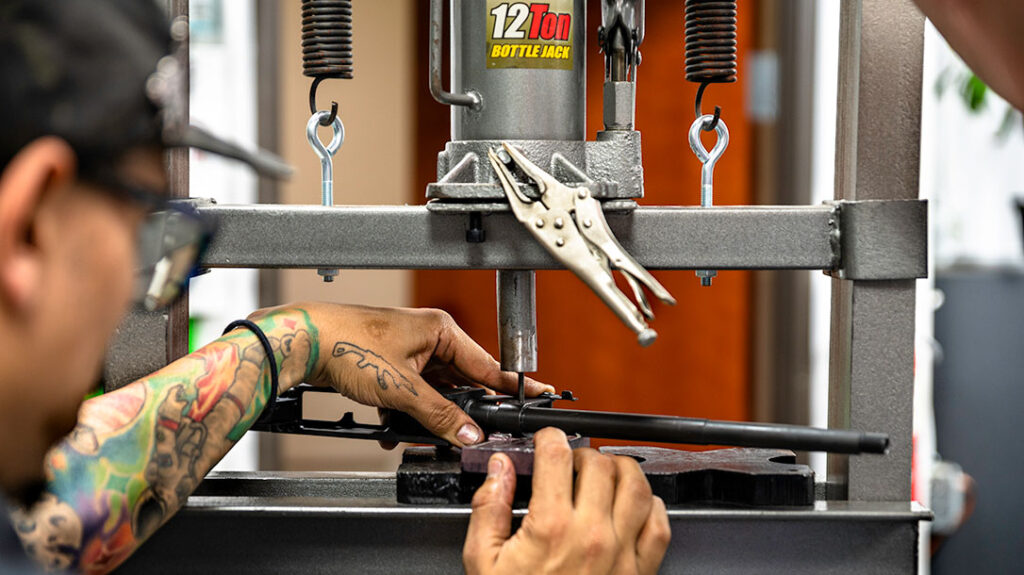 Rifle Dynamics staff member Titus helps the author properly press a pin into place in building this custom AK pistol.