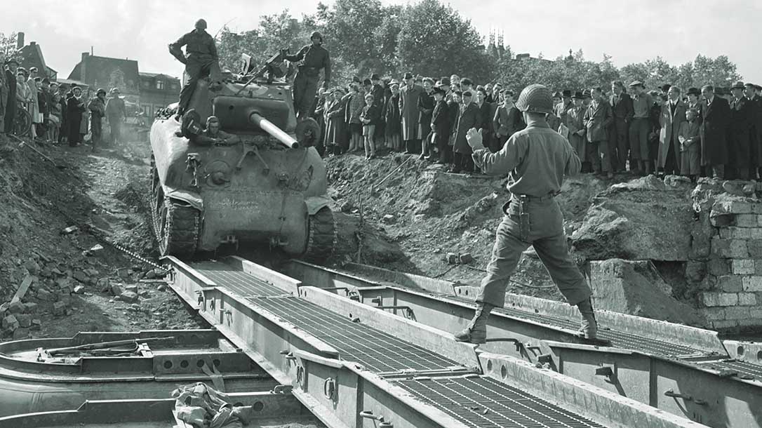 A Sherman M4 tank crosses an improvised bridge.