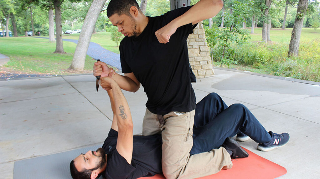 Combatives students train against a mounted attacker with a knife.
