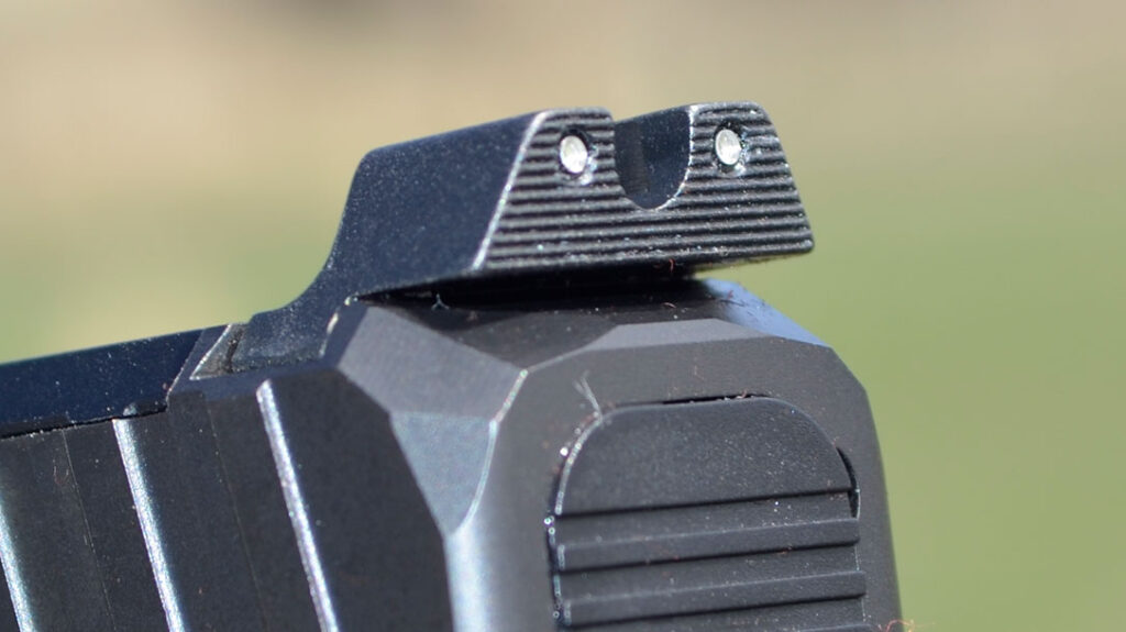 The rear sight features two tritium lamps on either side of the deep “U” notch.